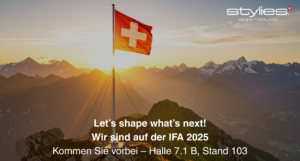 Schweizer Flagge auf einem Berggipfel bei Sonnenuntergang mit Textankündigung zur IFA 2025: ‚Let’s shape what’s next! Wir sind auf der IFA 2025 – Halle 7.1 B, Stand 103‘, Logo von Stylies oben rechts